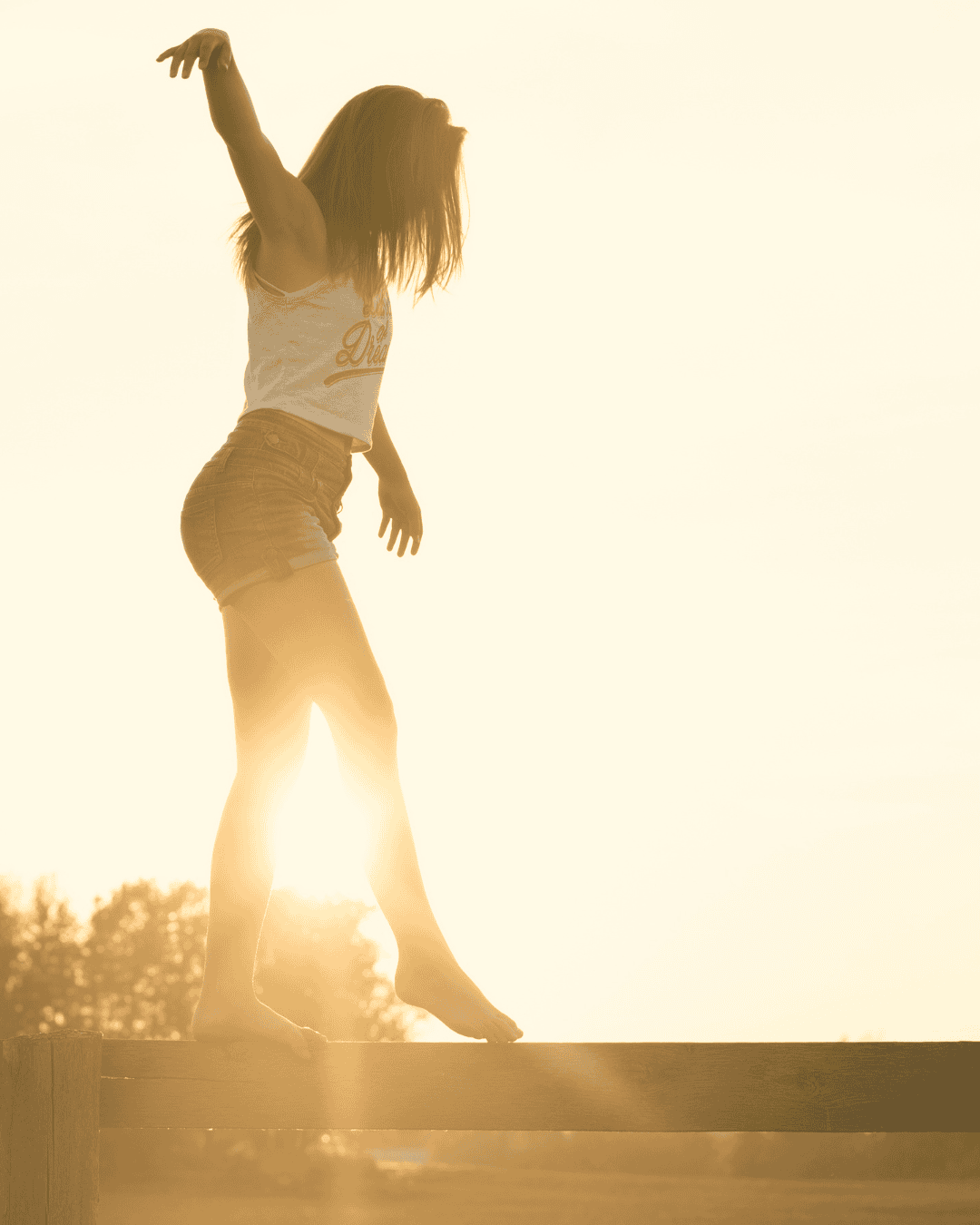 Frau tanzt im Sonnenuntergang, symbolisiert Selbstvertrauen und Lebensfreude.