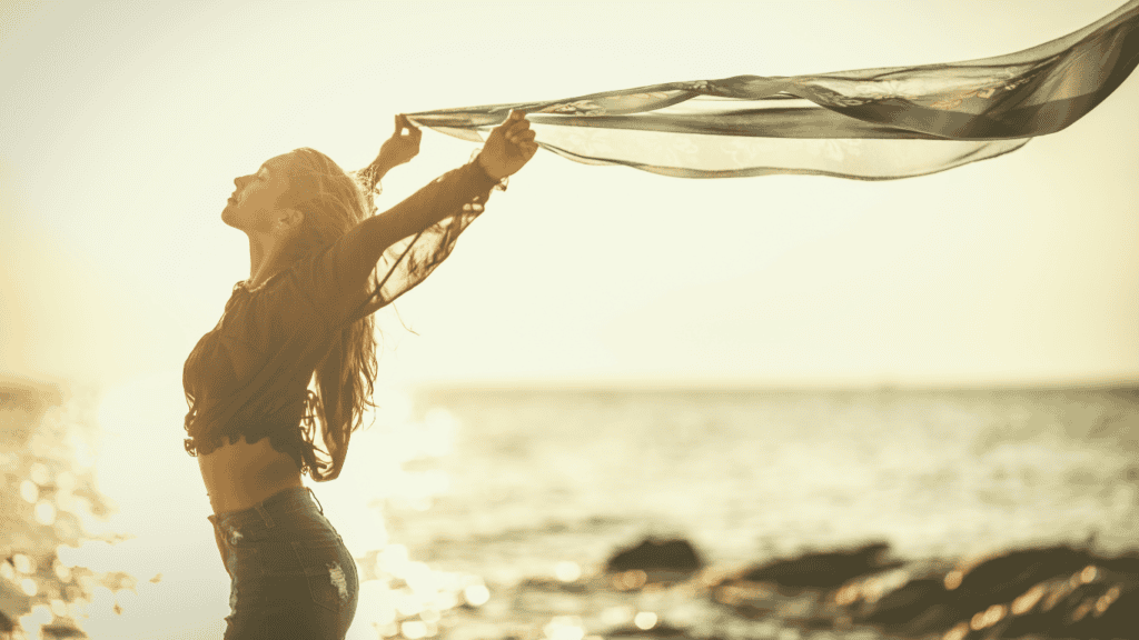 Frau bei Sonnenuntergang am Strand während einer Mentalklar Begleitung.